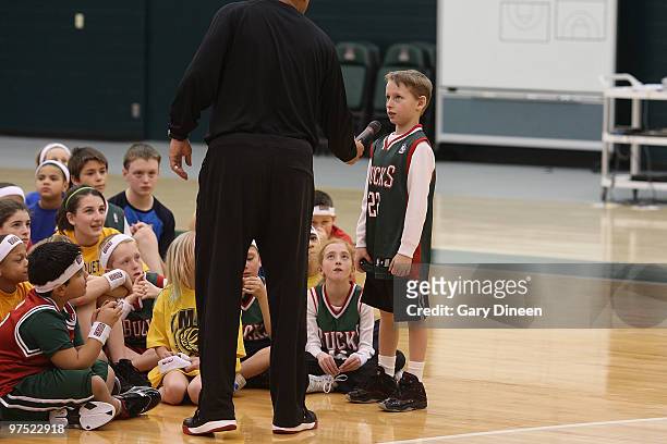 Milwaukee Bucks assistant coach Kelvin Sampson asks a participant about their learning experience during the annual YMCA basketball clinic on March...