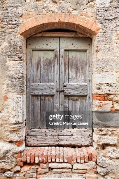wooden door, lucignano d'asso, tuscany, province of siena, italy - lucignano d'asso stock pictures, royalty-free photos & images