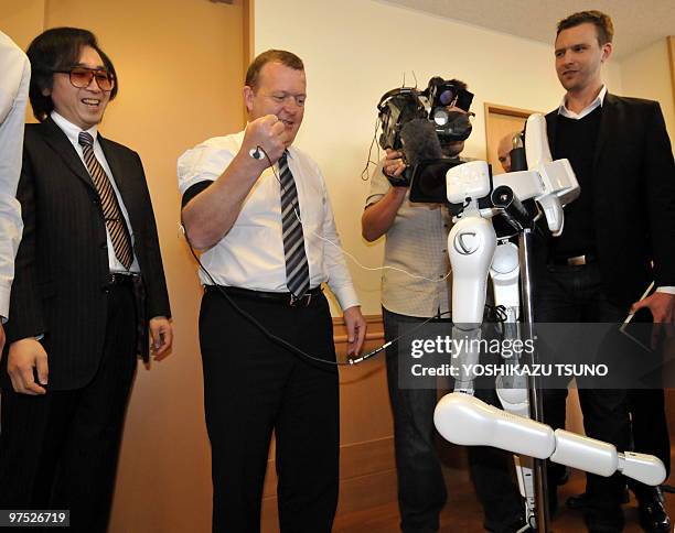 Danish Prime Minister Lars Lokke Rasmussen uses electromyography sensors to operate a Hybrid Assistive Limb as HAL developer Japanese university...