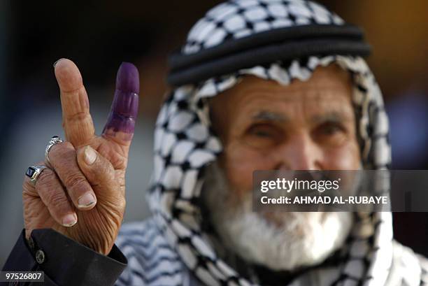An Iraqi man shows his ink-stained finger after casting his vote at a polling station in Baghdad's Shiite bastion of Sadr City on March 7, 2010....