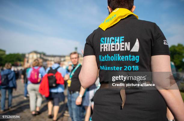 May 2018, Germany, Muenster: Thousands attend a Catholic service at the Palace, among them a woman wearing a t-shirt reading 'Suche Frieden' . From...