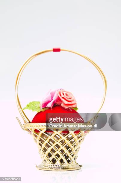 a miniature metalic wicker decorated by roses on a red velvet is - wicker heart stock pictures, royalty-free photos & images