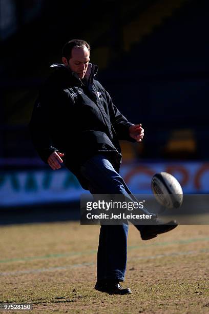 Saracens head coach Brendan Venter kicks a ball on the pitch before the game during the Guinness Premiership match between Leeds Carnegie and...