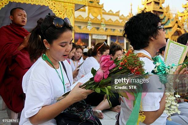 This picture taken on March 7, 2010 shows Thai tourists reciting prayers in the courtyard of the Shwedagon pagoda in Yangon. Myanmar is a mainly...