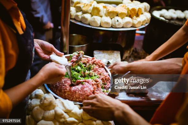 people holding a plate of meat at a market. - jason lin stock pictures, royalty-free photos & images