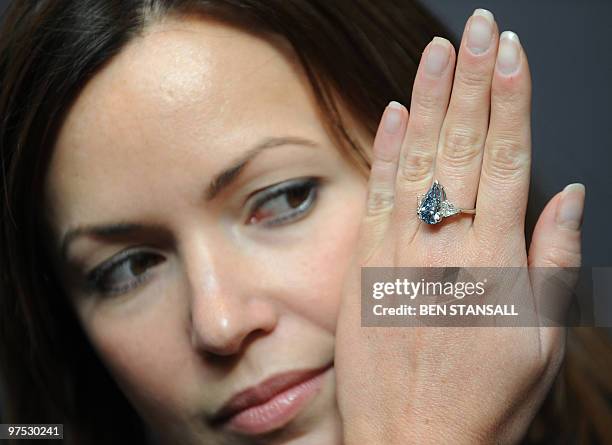 Sotheby's employee wears a 5.16-carat pear-shaped internally flawless fancy vivid blue diamond ring at Sotheby�s auction house in central London, on...