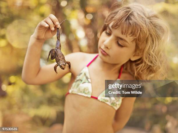 young girl holding and staring at a frog - wonderlust2015 stock pictures, royalty-free photos & images