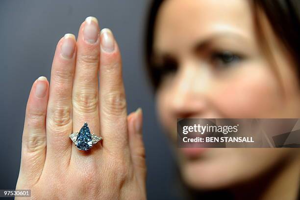 Sotheby's employee wears a 5.16-carat pear-shaped internally flawless fancy vivid blue diamond ring at Sotheby�s auction house in central London, on...