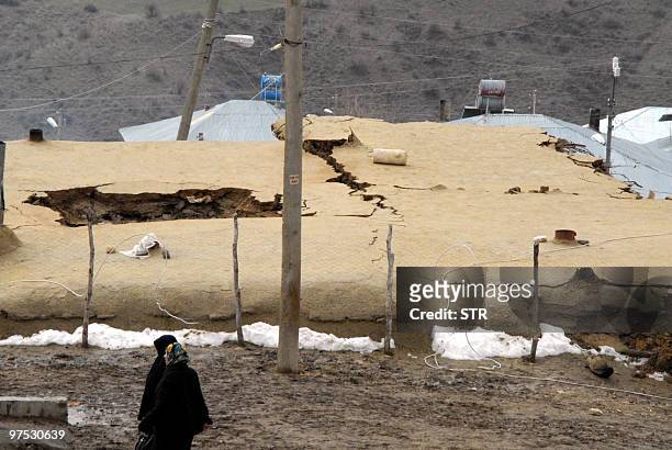Turkish villagers wait near their destroyed houses in the village of Okcular in Elazig province on March 8, 2010. At least 57 people have been killed...