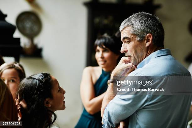 young girl in discussion with uncle in dining room during family celebration - uncle stock pictures, royalty-free photos & images