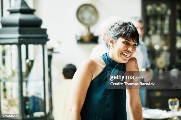 laughing woman hanging out with family members during celebration dinner - top mit nackenverschluß stock-fotos und bilder