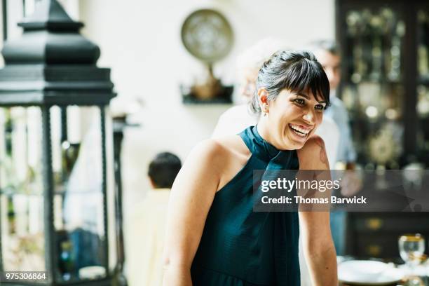 laughing woman hanging out with family members during celebration dinner - halter top foto e immagini stock