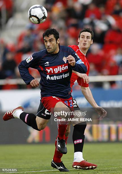 Mallorca's forward Aritz Aduriz vies for the ball with Sporting Gijon's defender Rafel Sastre during their Spanish league football match on March 7,...