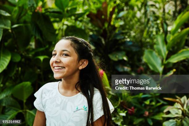portrait of smiling girl standing in backyard garden - lateinamerika stock-fotos und bilder