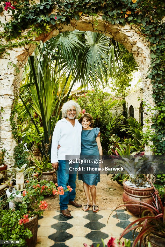 Portrait of senior couple embracing in backyard garden during dinner party