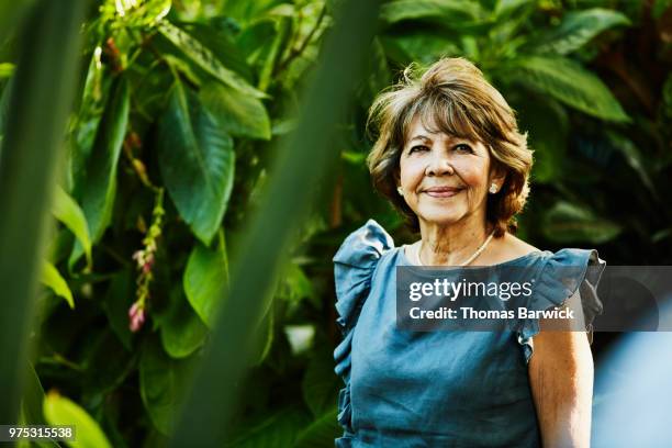 Portrait of senior woman standing in backyard garden during dinner party