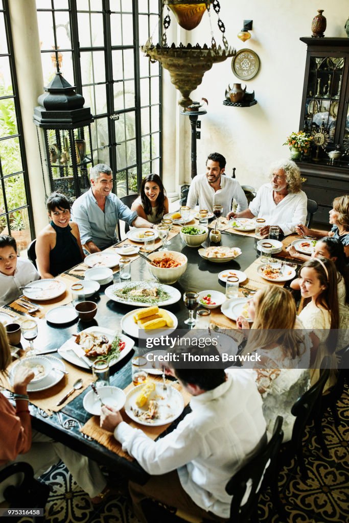 Overhead view of multigenerational family gathered at dining room table for celebration meal