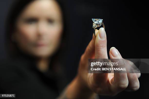 Sotheby's employee holds a 5.16-carat pear-shaped internally flawless fancy vivid blue diamond ring at Sotheby�s auction house in central London, on...