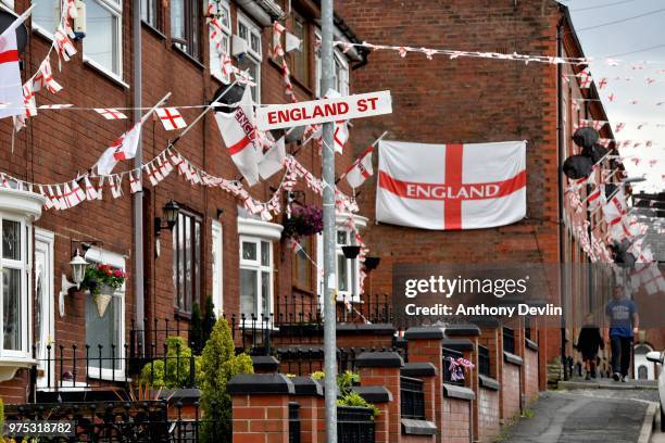 Residents walk along Wales Street in Oldham which local residents have re-named England Street and decorated with flags to celebrate the FIFA World...