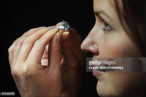 Sotheby's employee holds a 5.16-carat pear-shaped internally flawless fancy vivid blue diamond ring at Sotheby�s auction house in central London, on...