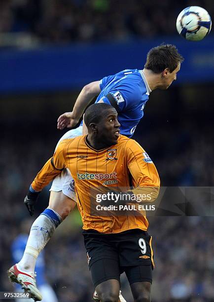 Everton's English defender Phil Jagielka jumps above Hull City's US forward Jozy Altidore during their English Premier League football match at...
