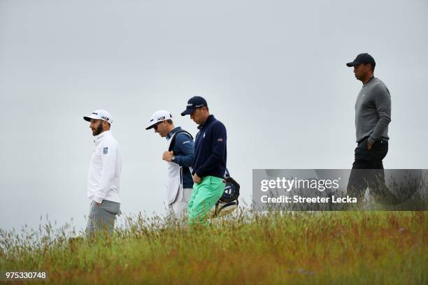 Dustin Johnson of the United States, caddie Jimmy Johnson, Justin Thomas of the United States, and Tiger Woods of the United States walk the 13th...