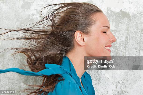 profile of young woman with wind in her hair - hair wind stock pictures, royalty-free photos & images