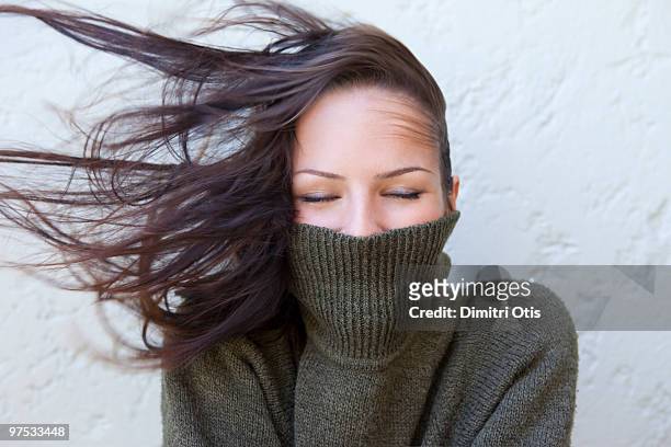 woman with polar neck jumper and wind in her hair - neckline stock pictures, royalty-free photos & images