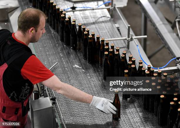 May 2018, Germany, Rothaus: An employee of Baden's state brewery Rothaus checks a bottle of beer at the filling line. According to statements,...