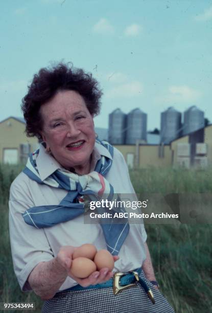 Julia Child at a farm holding eggs.