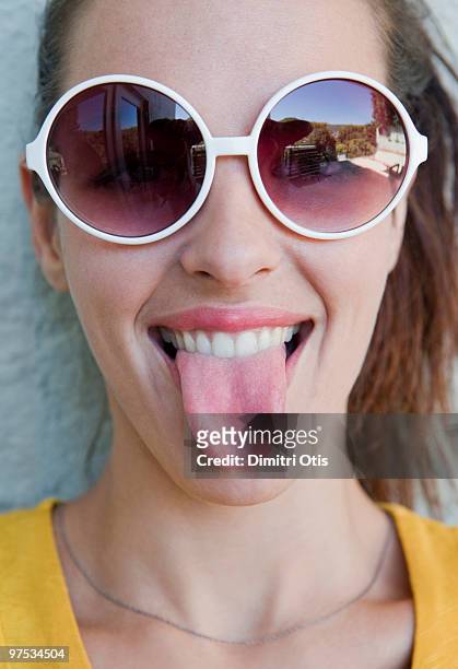 young woman with sunglasses, showing her tongue - sticking out tongue stock pictures, royalty-free photos & images