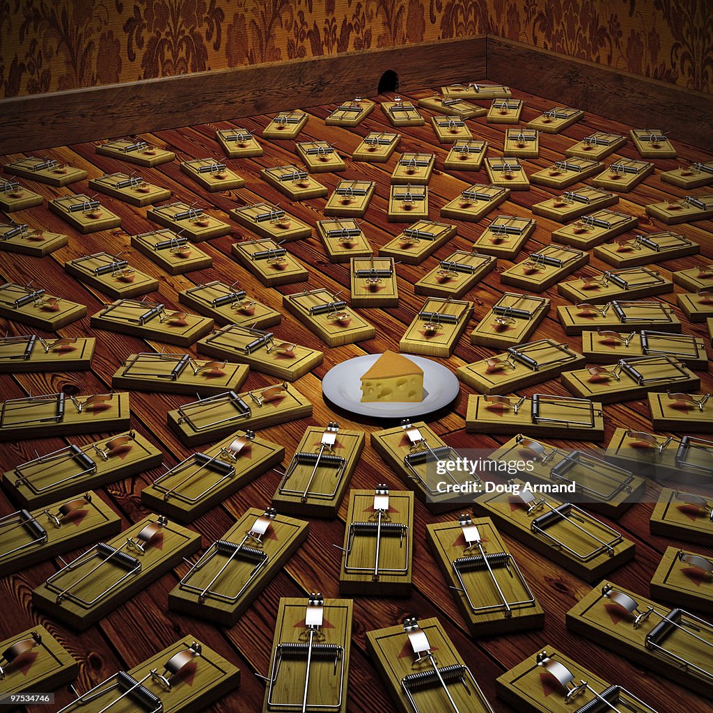 A piece of cheese surrounded by mousetraps