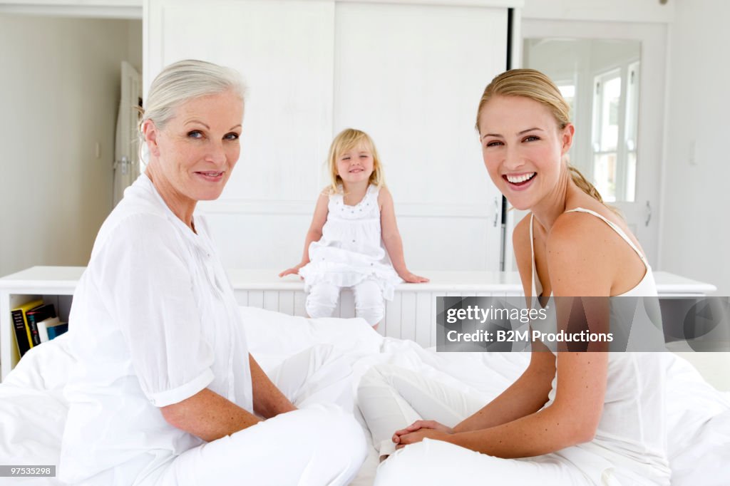 Grandmother, mother and girl (3-4) on bed