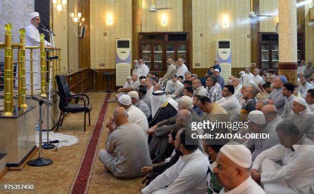 Iraqi worshippers attend a sermon given by a Sunni Muslim cleric during Eid al-Fitr prayers as they mark the religious holiday after the end of the...