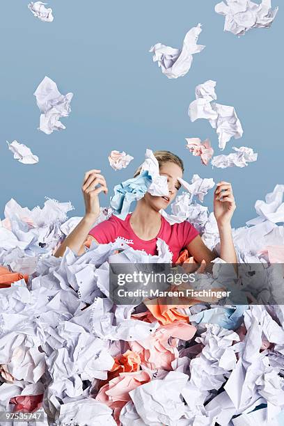 young girl in big pile of paper - mareen fischinger foto e immagini stock