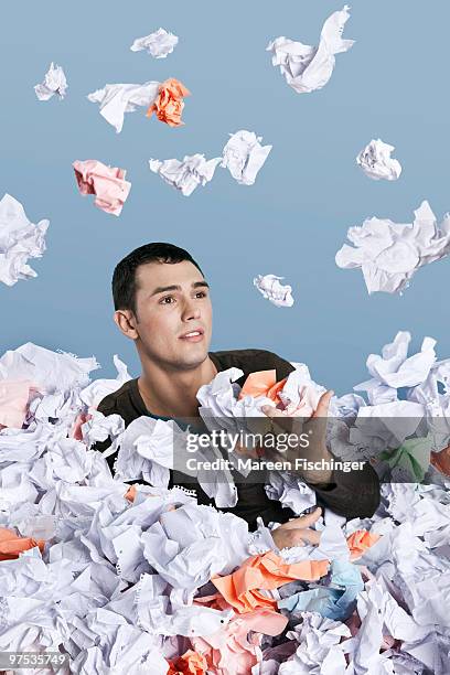 young man in big pile of paper - mareen fischinger foto e immagini stock