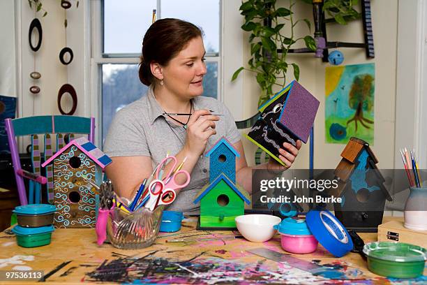 woman painting decorative birdhouses - natick stock pictures, royalty-free photos & images