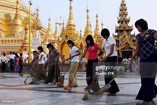 This picture taken on March 7, 2010 shows Myanmar women sweeping the courtyard of the Shwedagon pagoda in Yangon. Myanmar is a mainly Buddhist...