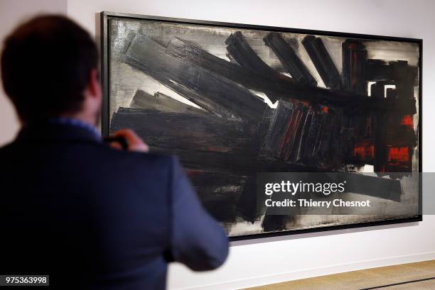 Visitor takes a picture of a painting by French painter Pierre Soulages during a press visit at the Pierre Gianadda Foundation on June 15, 2018 in...