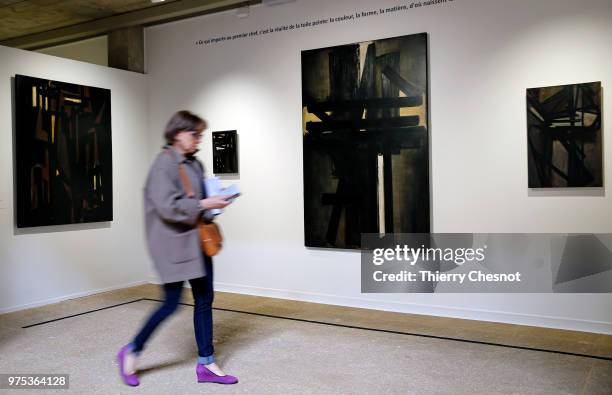 Walks past a painting , by French painter Pierre Soulages during a press visit at the Pierre Gianadda Foundation on June 15, 2018 in Martigny,...