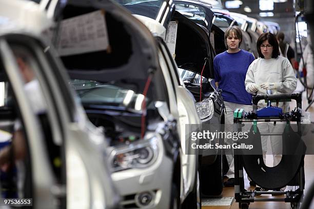 Female workers assemble Volkswagen Golf and Tiguan cars on the assembly line at the VW factory on March 8, 2010 in Wolfsburg, Germany. Volkswagen...