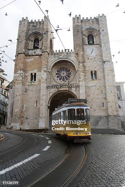 Tram passes the Lisbon Cathedral, Santa Maria Maior de Lisboa, in Lisbon, Portugal, on Sunday, March 7, 2010. The Portuguese government may reduce...