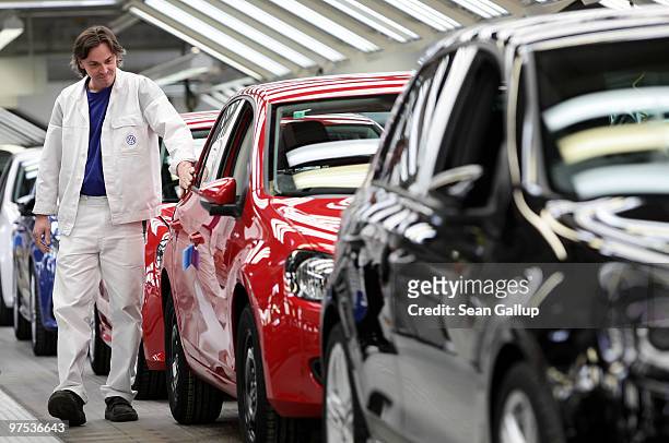 Worker inspects finsihed Volkswagen Golf cars at the end of the assembly line at the VW factory on March 8, 2010 in Wolfsburg, Germany. Volkswagen...