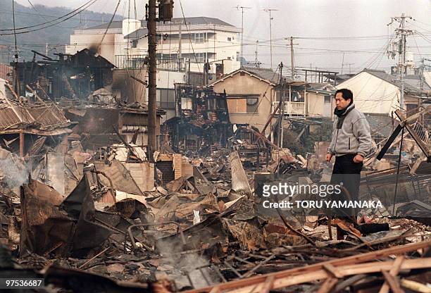 Resident walks through debris of burnt down houses 18 January 1995 in Kobe after a massive earthquake rocked Western Japan 17 January. The Hyogo-Ken...