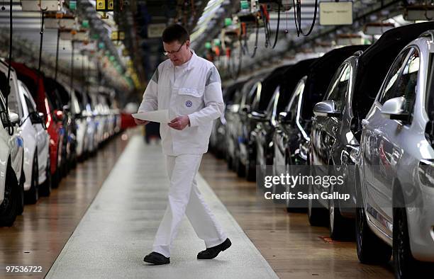 Worker walks by finsihed Volkswagen Golf cars at the end of their assembly line at the VW factory on March 8, 2010 in Wolfsburg, Germany. Volkswagen...