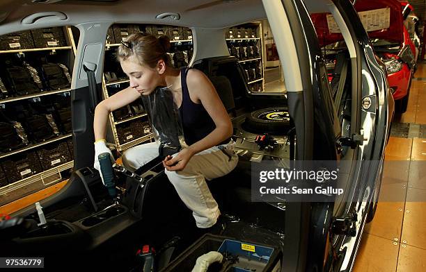 Female worker assembles part of the interior of a Volkswagen Golf car on the assembly line at the VW factory on March 8, 2010 in Wolfsburg, Germany....