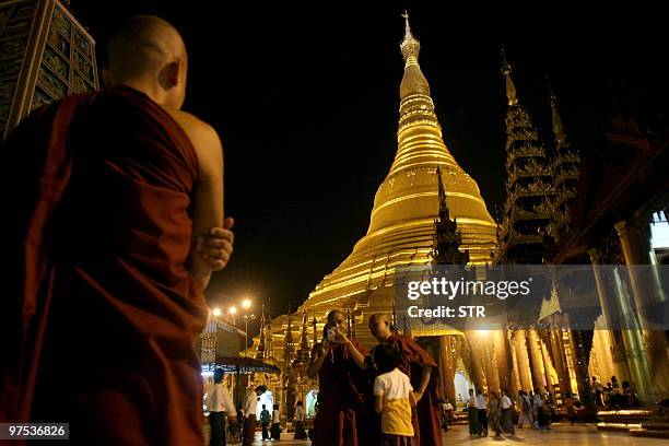 This picture taken on March 7, 2010 shows a Myanmar monk posing for pictures in the courtyard of the Shwedagon pagoda in Yangon. Myanmar is a mainly...