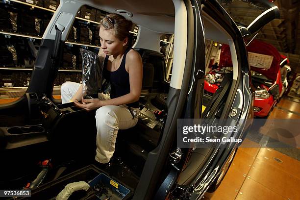 Female worker assembles part of the interior of a Volkswagen Golf car on the assembly line at the VW factory on March 8, 2010 in Wolfsburg, Germany....