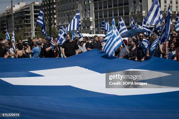 People seen holding a large Greek flag and shouting slogans at the demonstration. People demonstrated in Syntagma square, Athens, in protest at the...