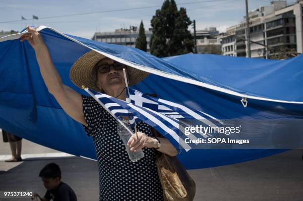 Woman seen holding a large Greek flag and shouting slogans at the demonstration. People demonstrated in Syntagma square, Athens, in protest at the...